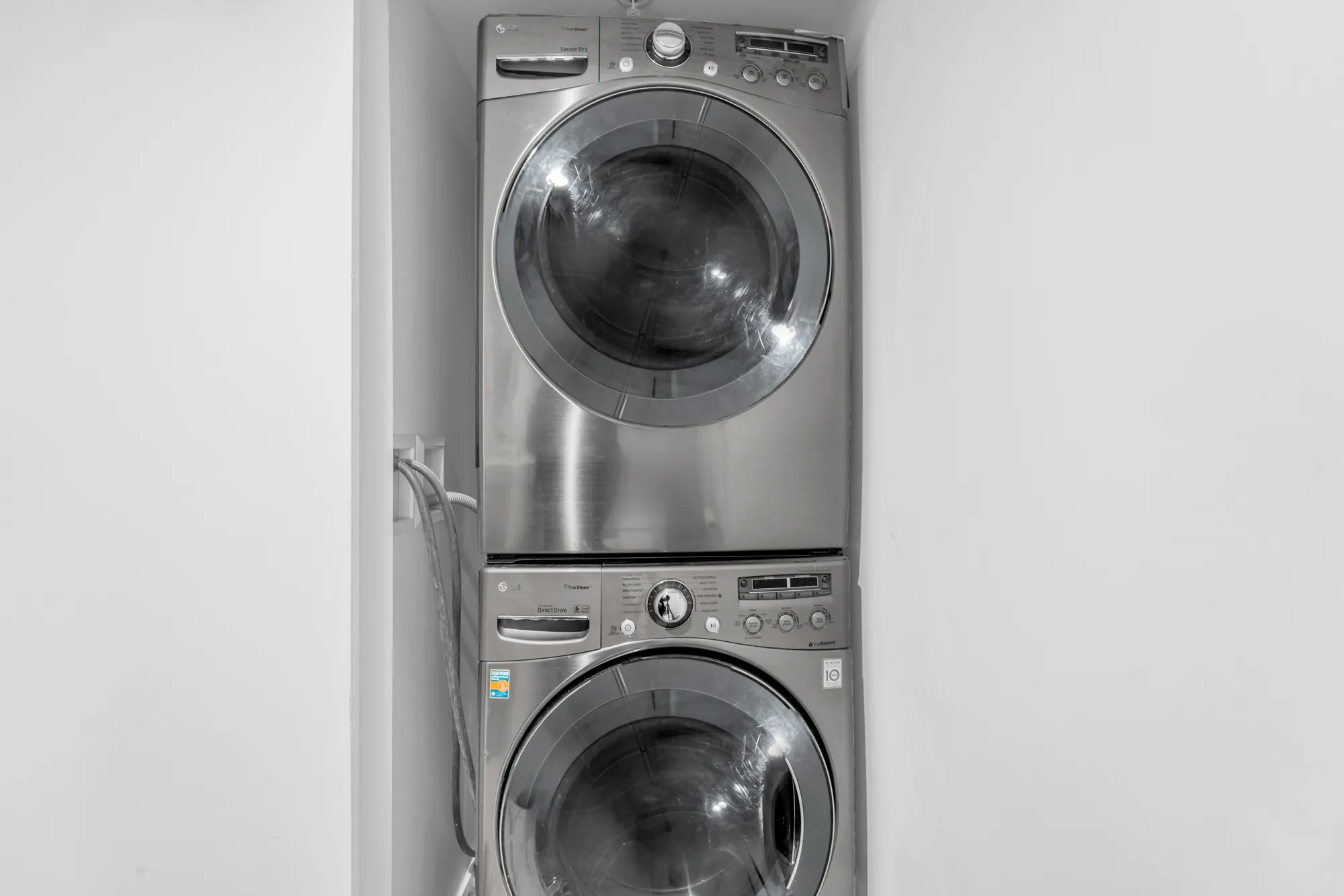 The stacked front-loading washer and dryer in their closet