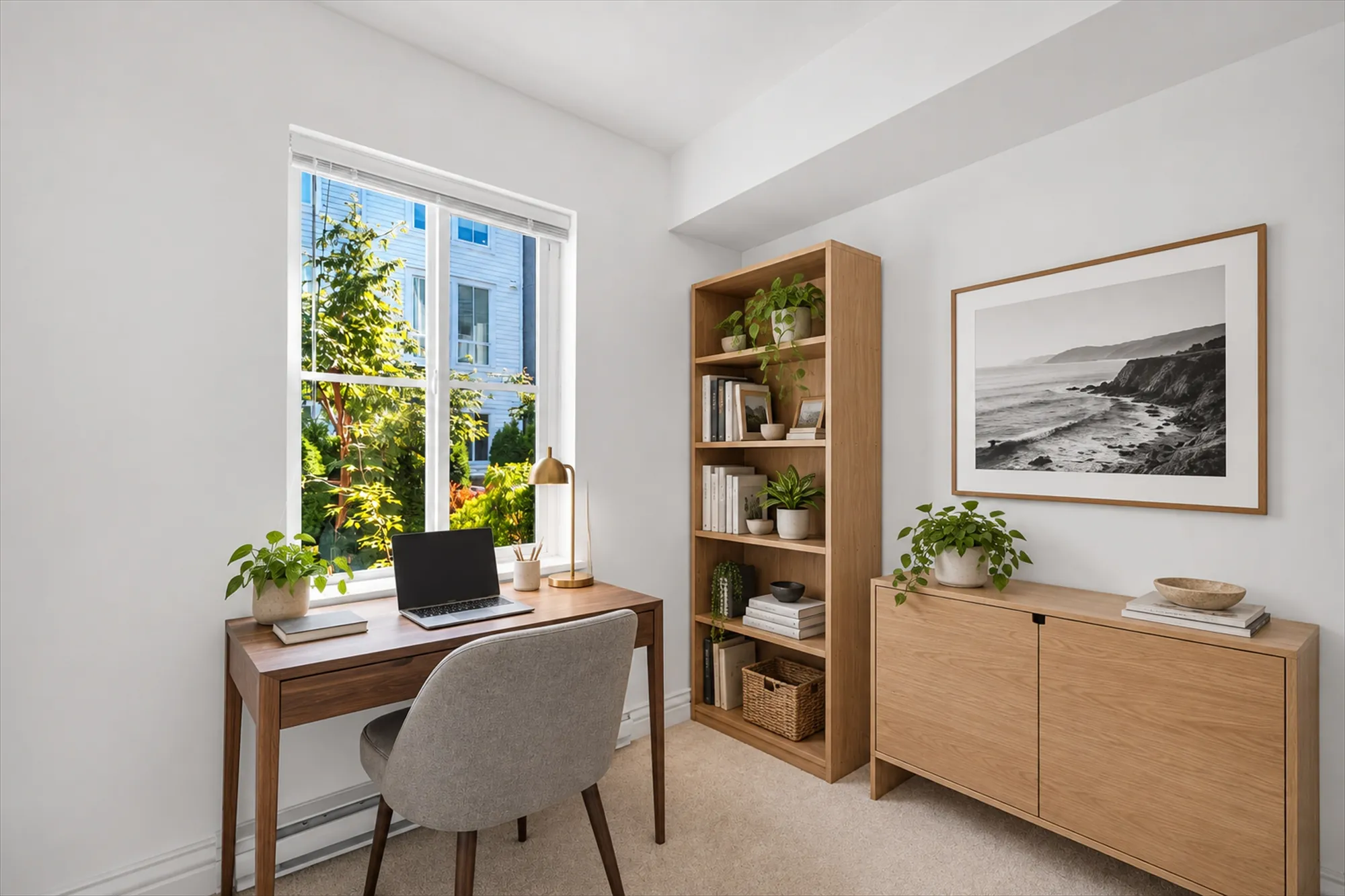The office virtually staged: a wood desk and chair under the window to the front walk, a bookcase, a low cabinet, a black-and-white photograph
